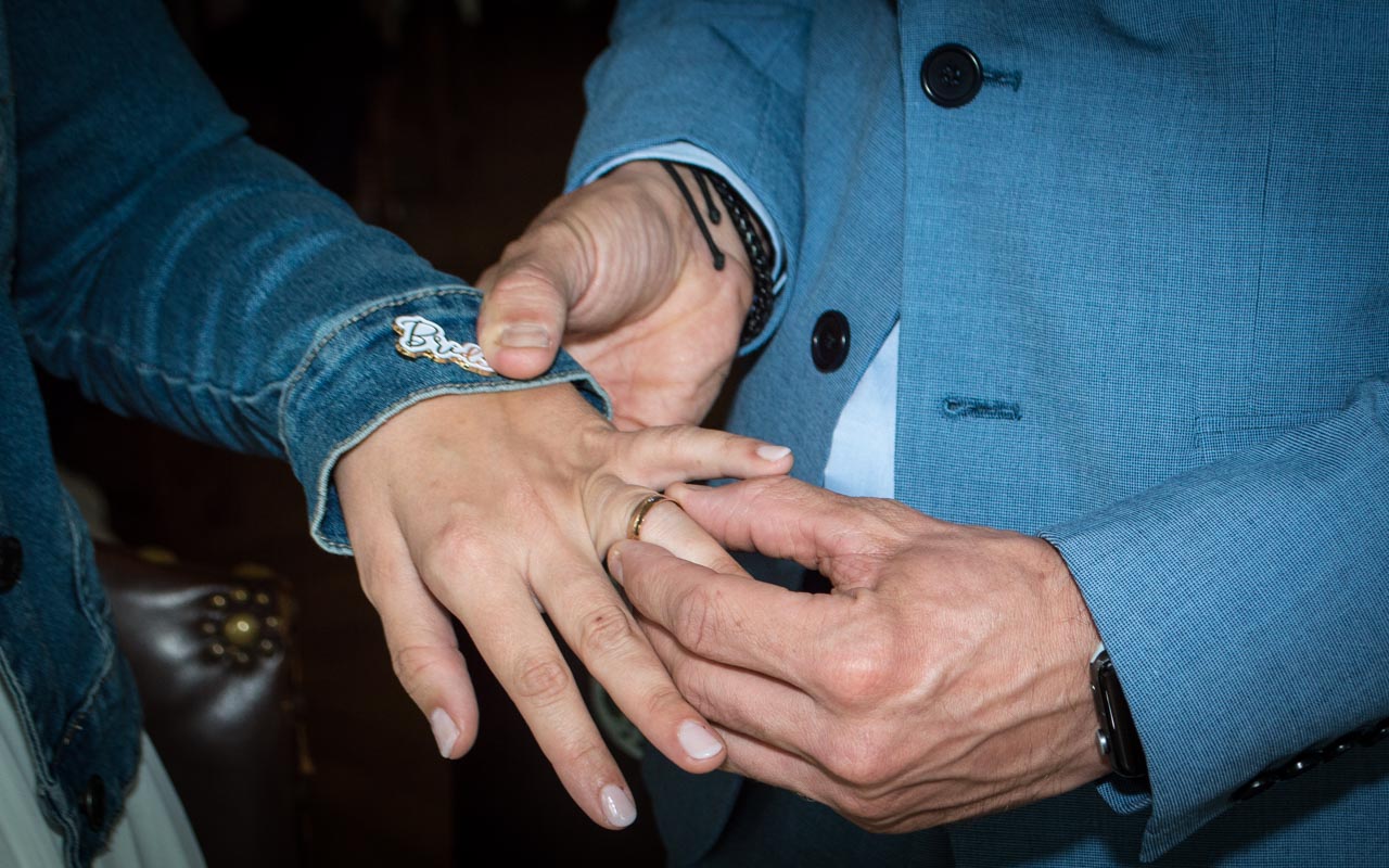 Bruid doet ring om bij bruidegom