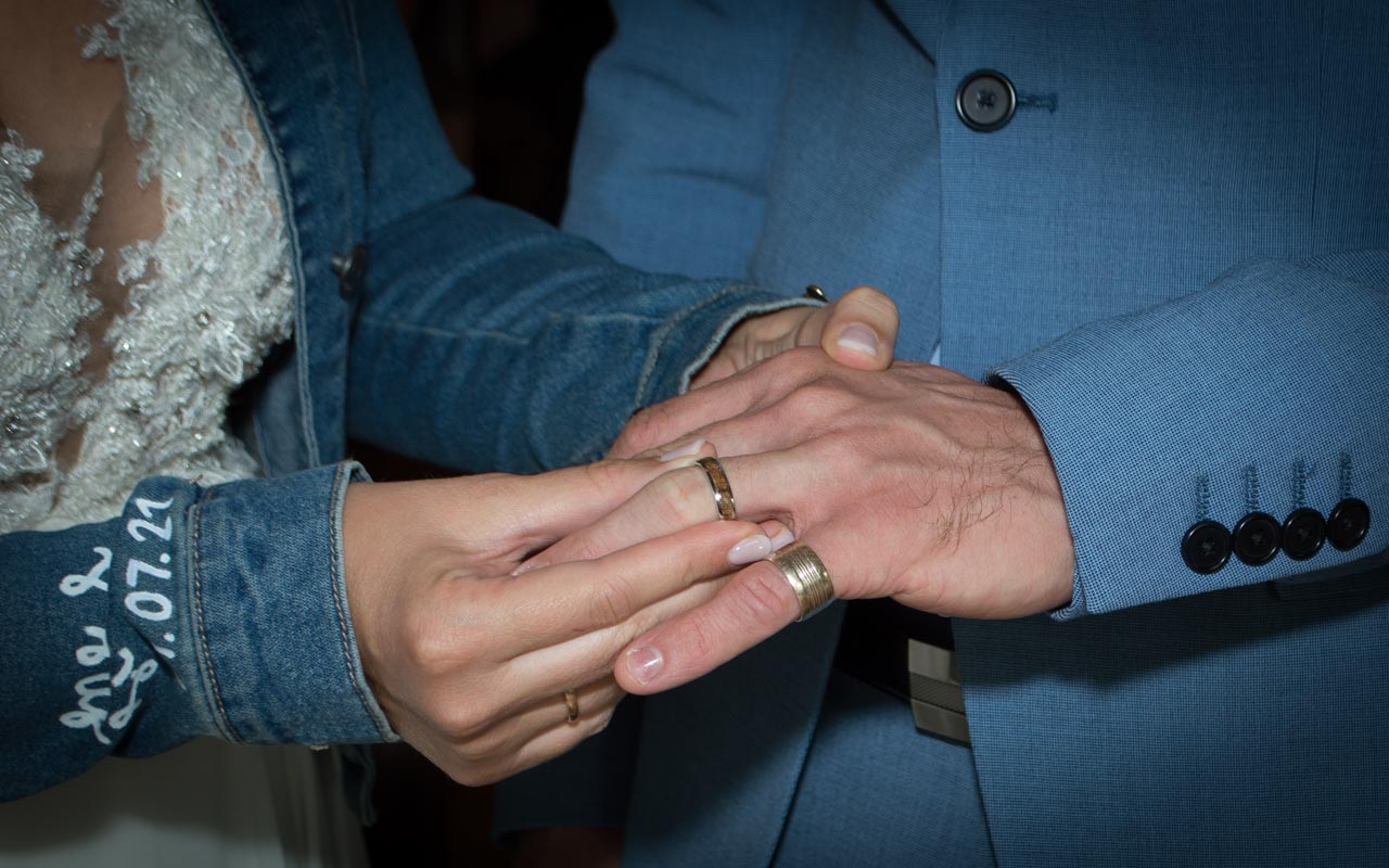 bruidegom doet ring om bij bruid
