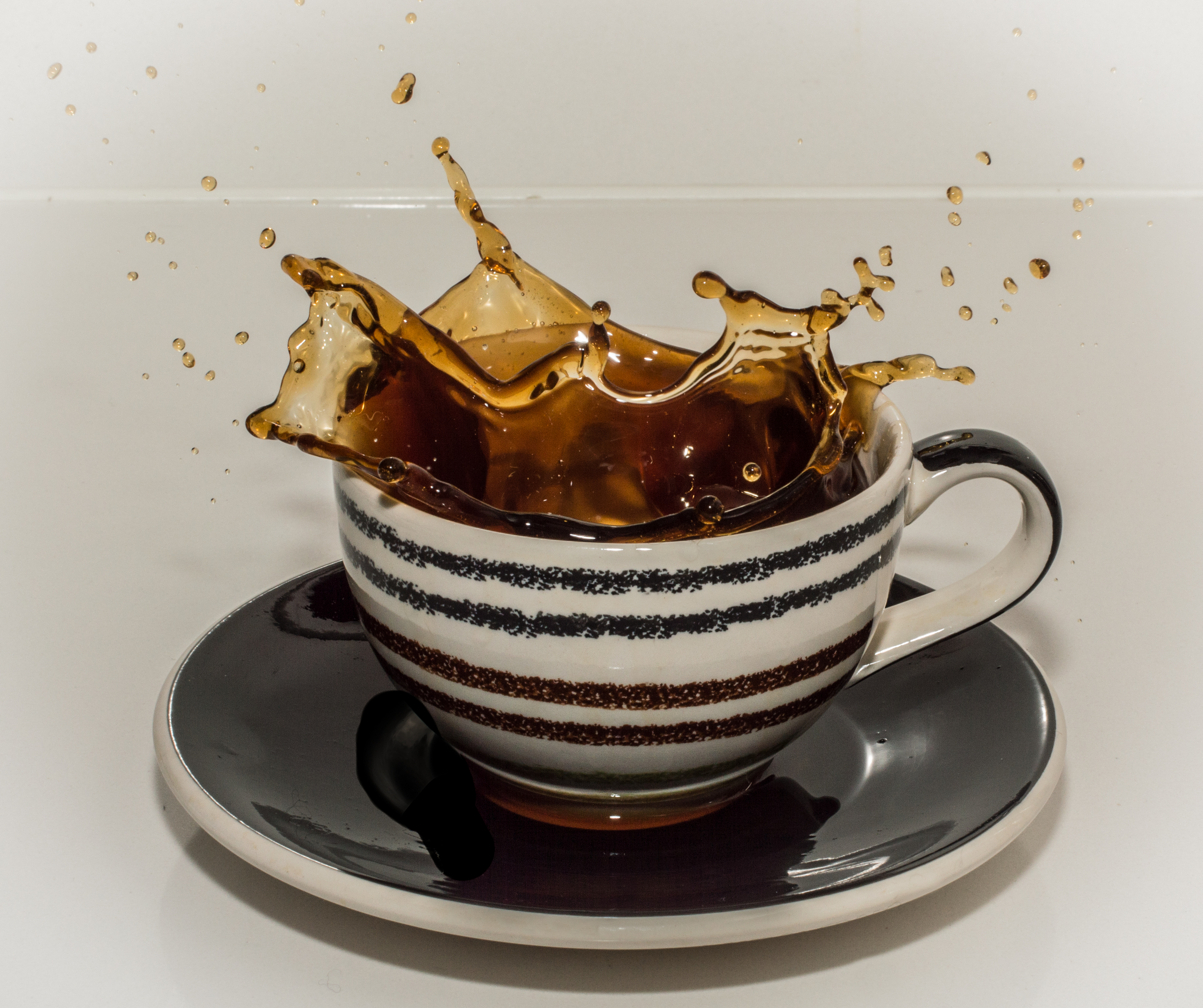 koffietas met koffie die eruit splasht